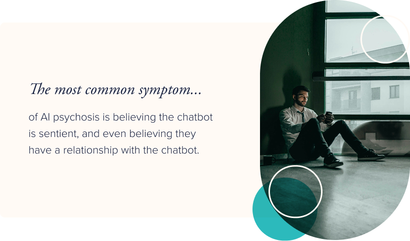 Image: A man in a dark room, sitting on the floor looking at his phone. Text: The most common symptom of AI psychosis is believing the chatbot is sentient, and even believing they have a relationship with the chatbot.