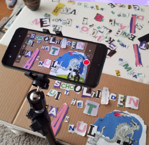Foto van een telefoon die een stop-motion animatie maakt van uitgeknipte letters op een tafel.