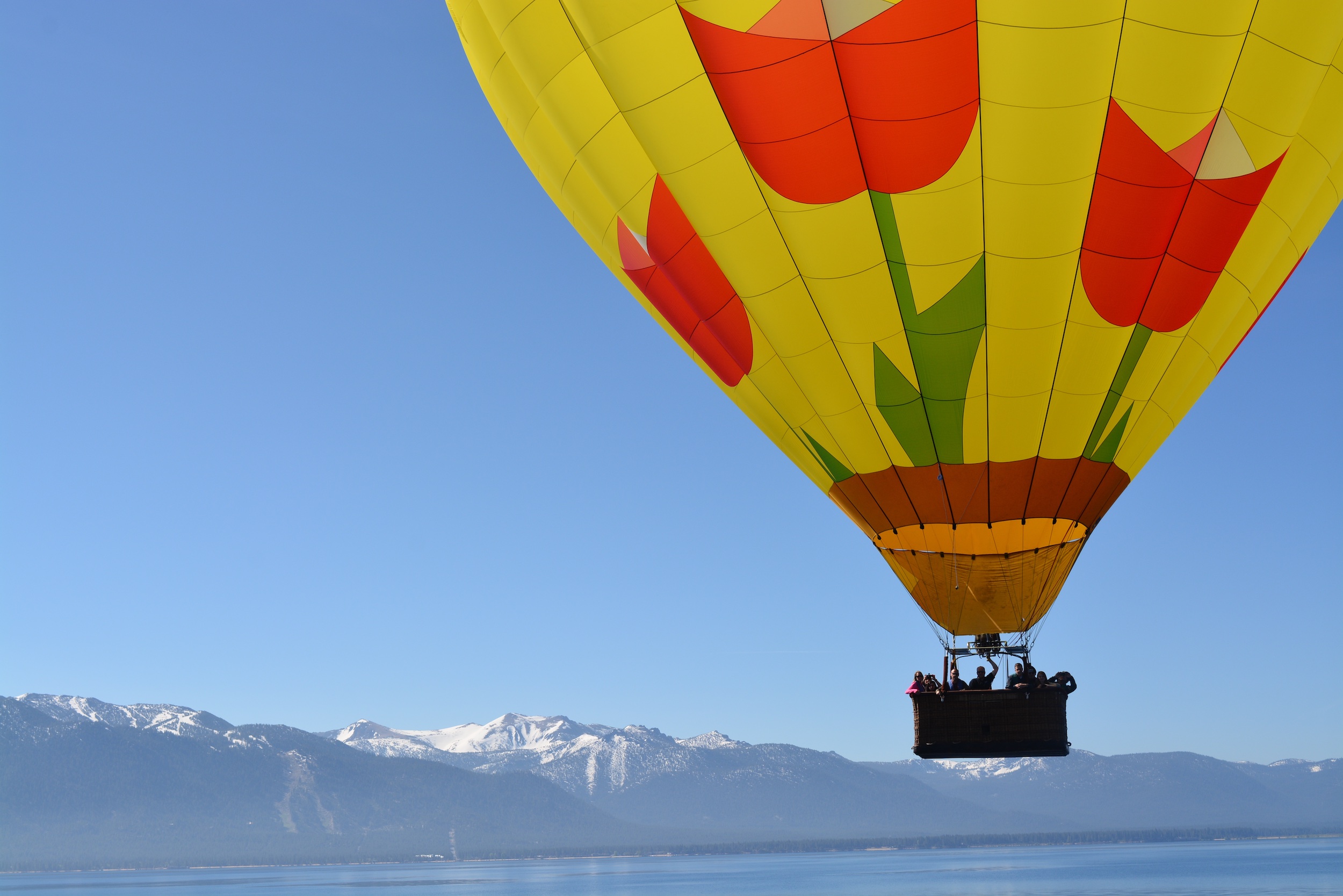 Hot air balloon lifting off over Lake Tahoe at sunrise