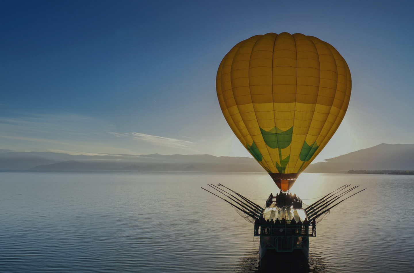 Silhouette of a hot air balloon at dawn on the lake