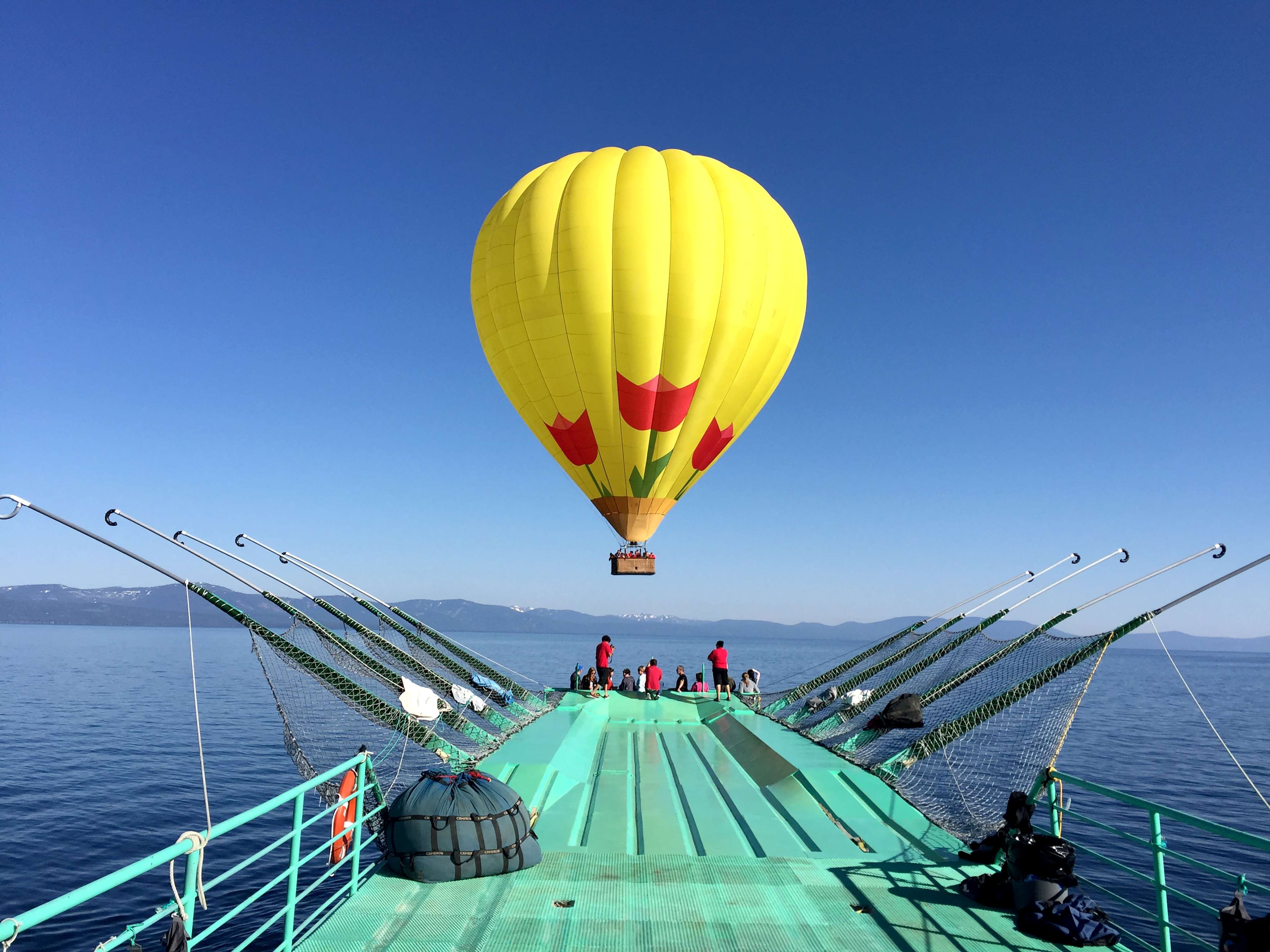 Hot-air balloon lifting off the deck of the launch boat on Lake Tahoe