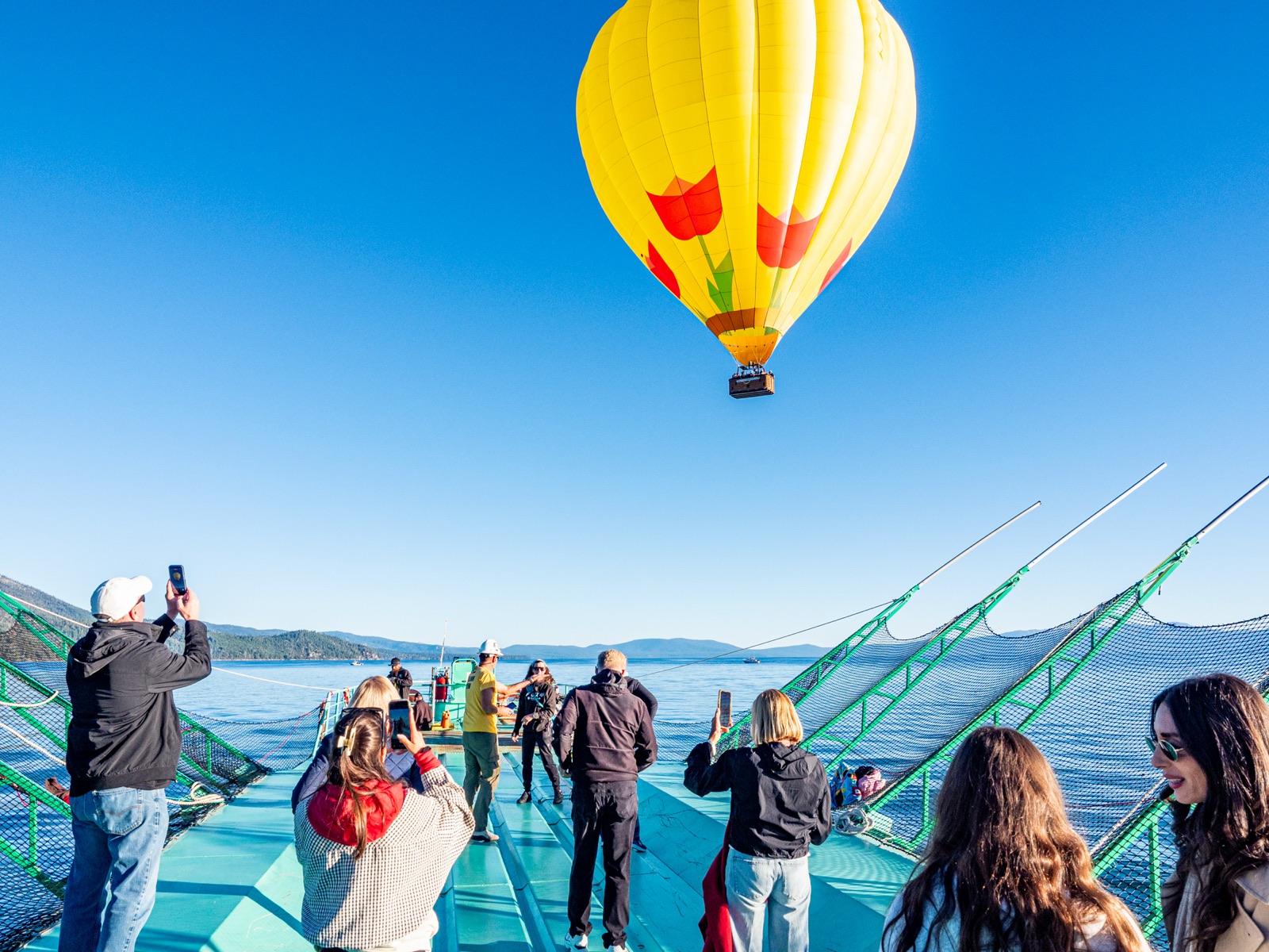 Guests on the boat deck photographing the balloon as it lifts off