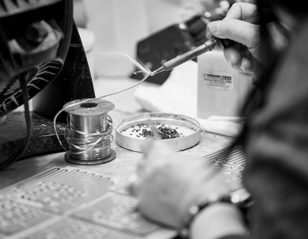 A worker using a soldering iron on a component