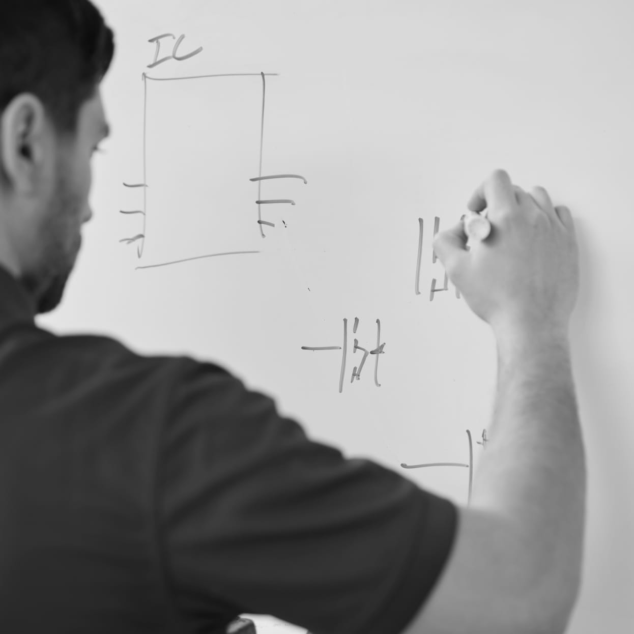 An engineer drawing diagrams on a whiteboard