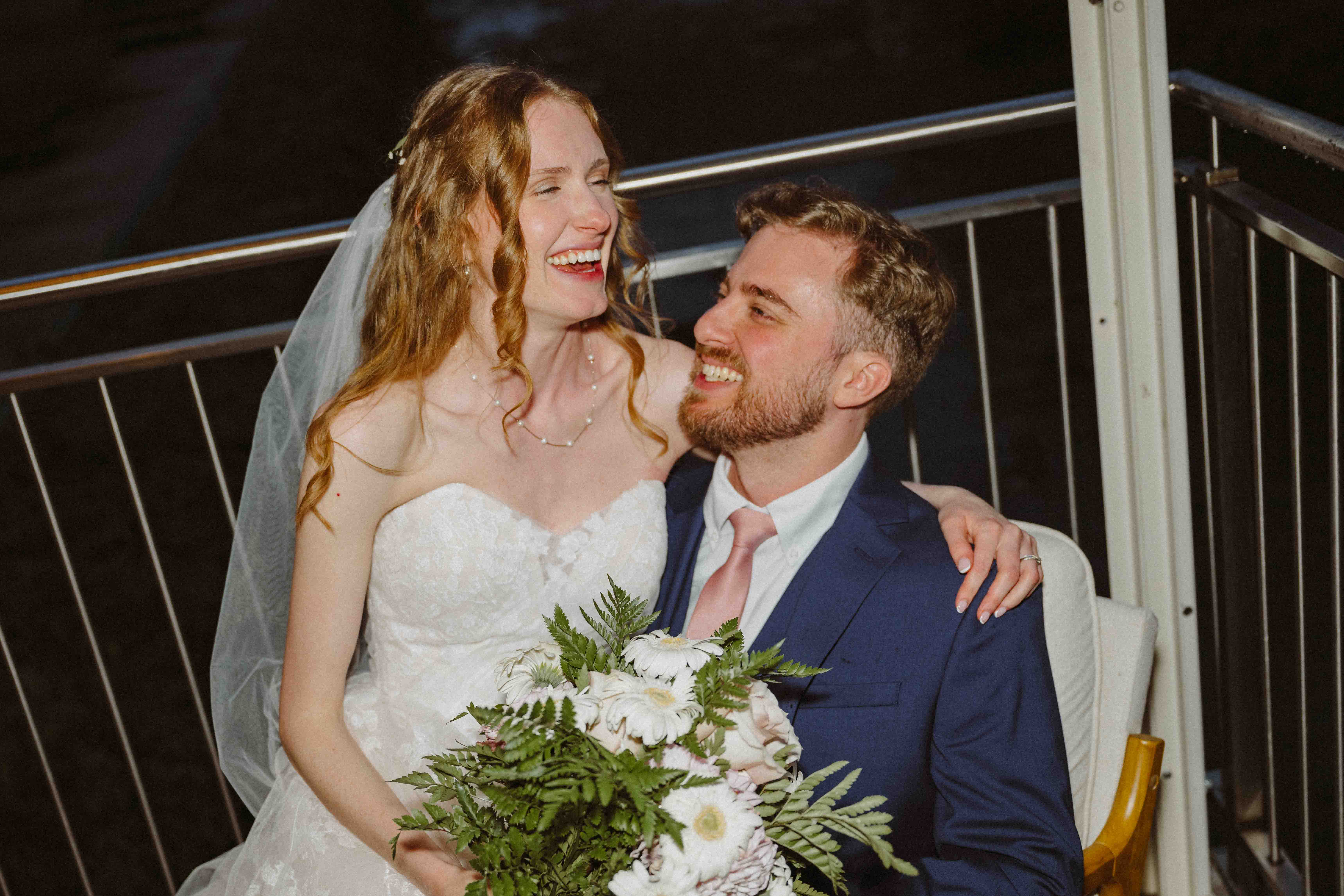 Couple laughing together on their wedding day.