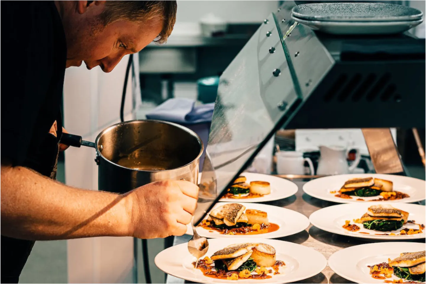 Chef qui termine une série de plats en cuisine