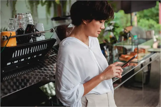 Une restauratrice consulte son téléphone intelligent