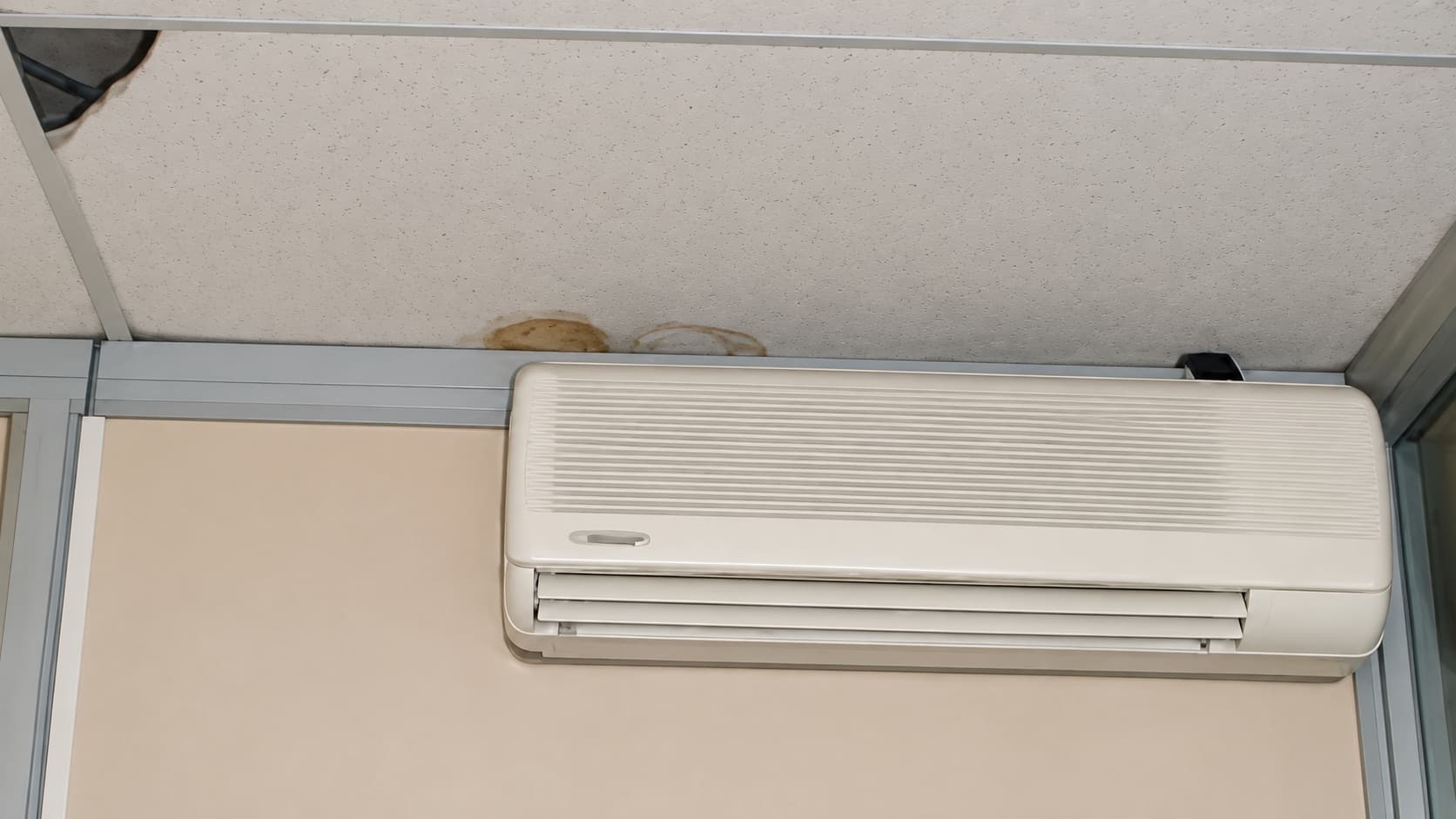 Dégradation d'un faux plafond et traces liées à l'humidité d'un climatiseur