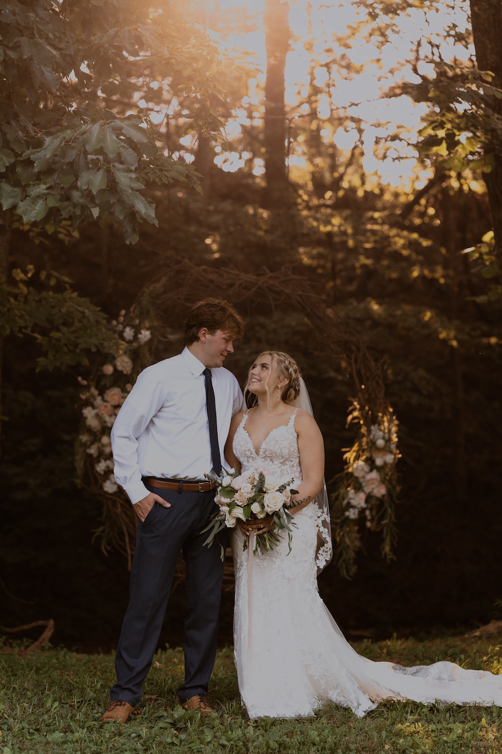Monica & Caleb pause for a golden hour portrait in front of the grapevine circle at The Barn at Cedar Grove in Kentucky