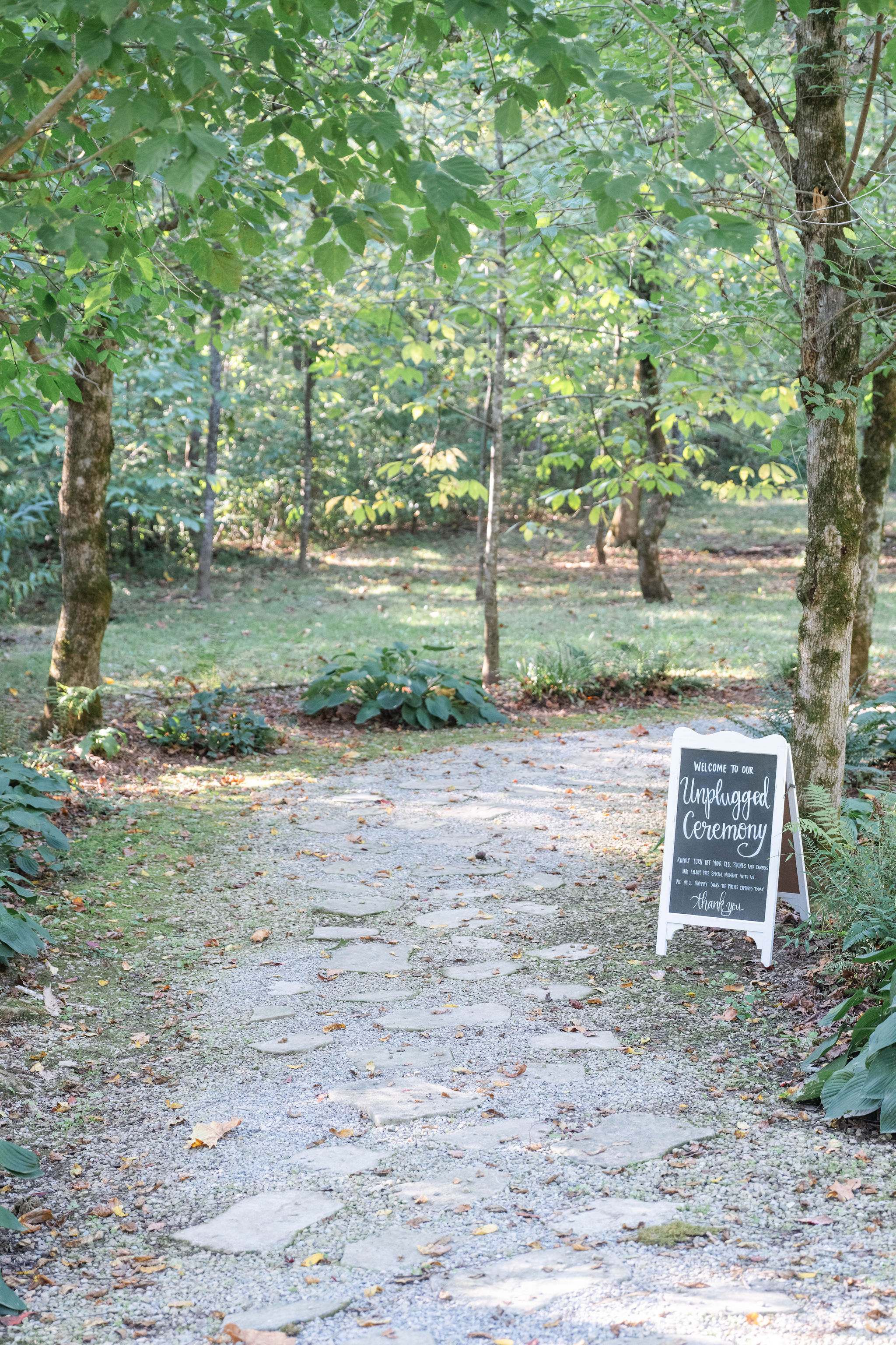 woodland path into the forest ceremony area at The Barn at Cedar Grove between Greensburg and Columbia KY.  Note the "unplugged" ceremony sign.