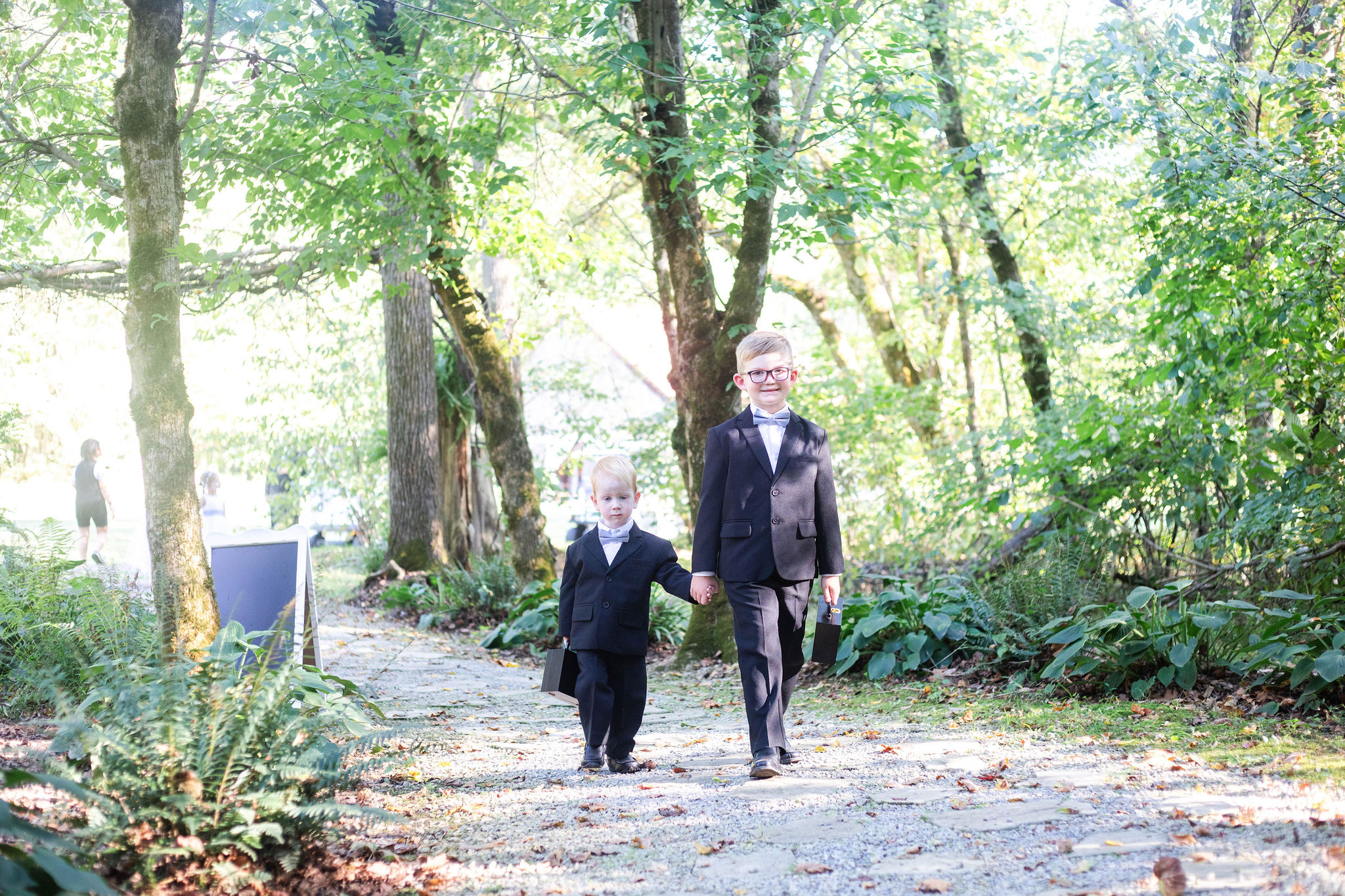 The cutest ring security duo as they walk down the woodland path to Hannah & Michael's ceremony in the woods at The Barn at Cedar Grove 