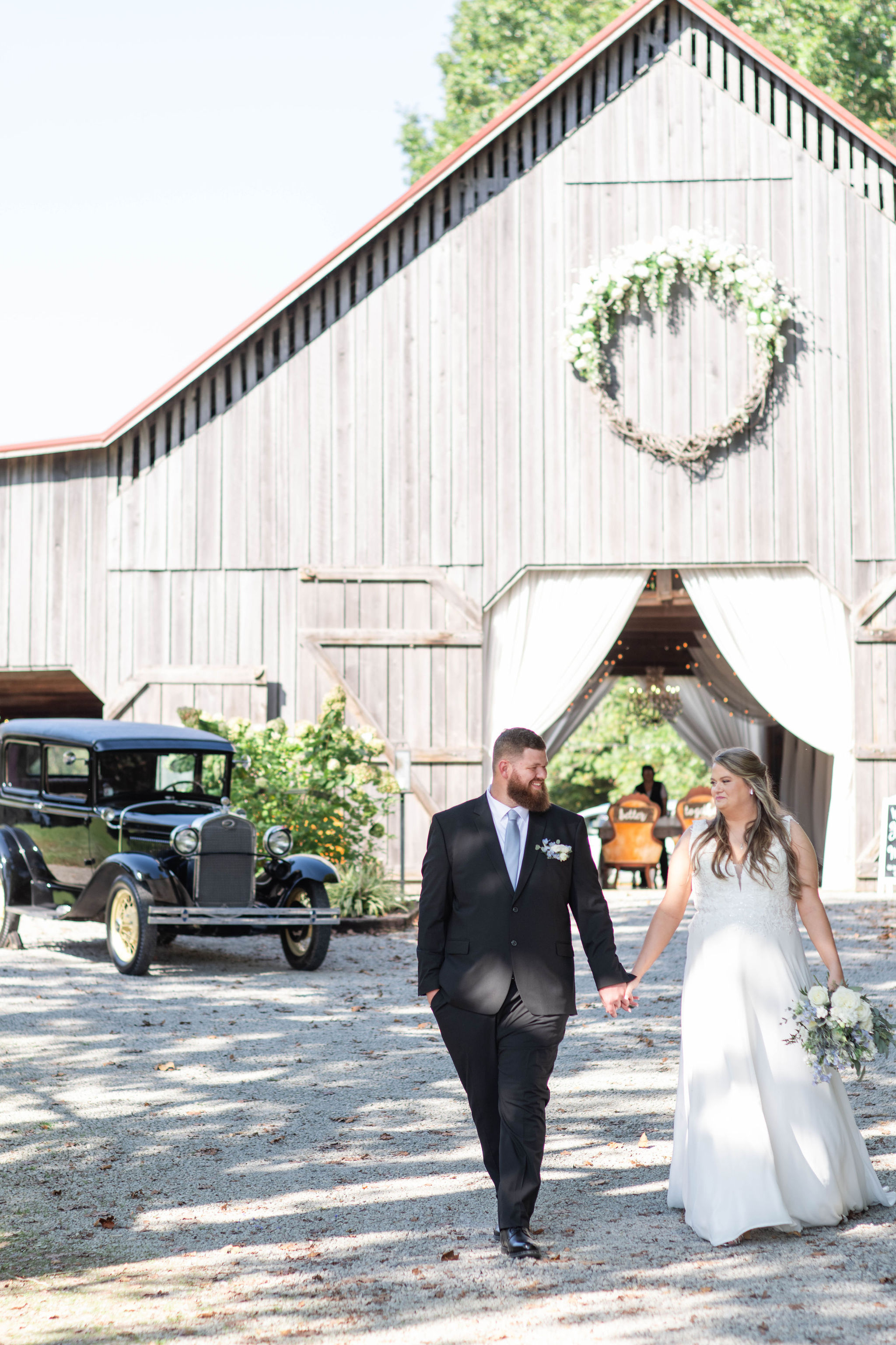 Hannah & Michael wedding portrait in front of The Barn at Cedar Grove with their antique car in the background.