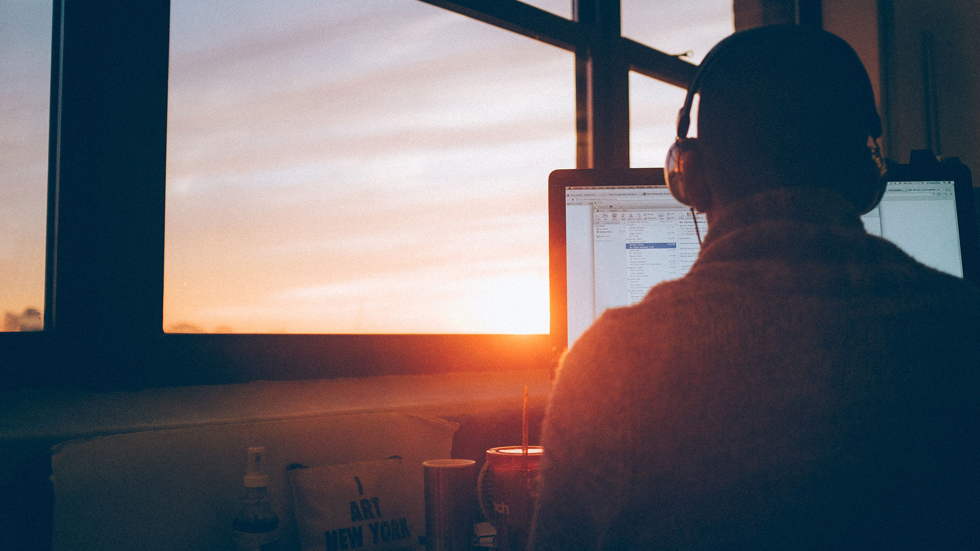 Man working at a computer during sunset