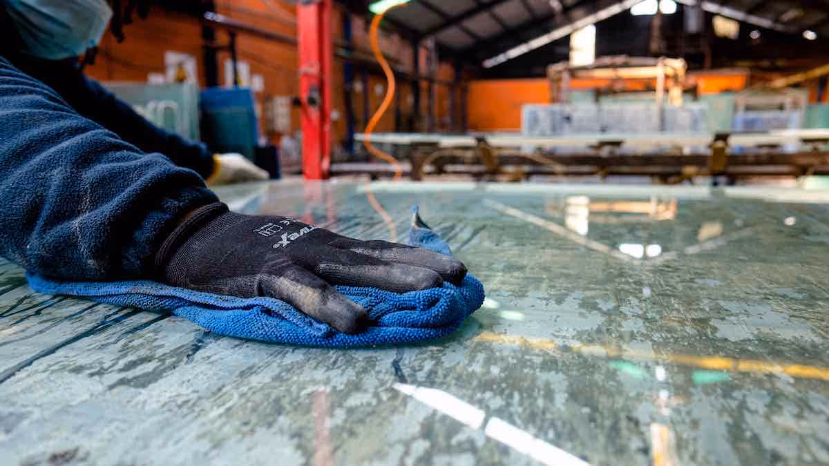 A worker polishing a sheet of recycled acrylic