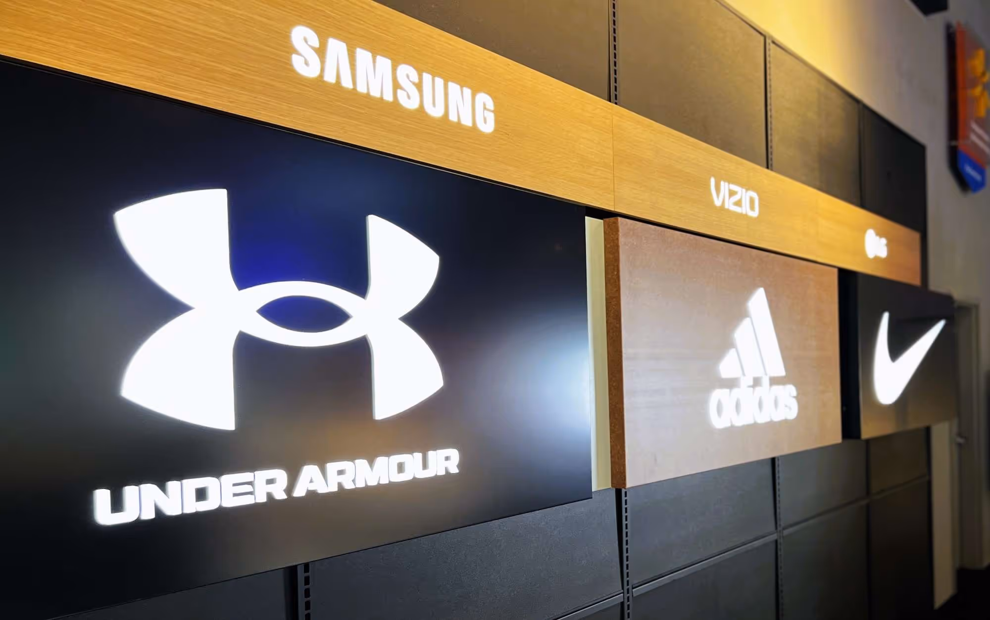 Signs and letters for brands like Samsung, Under Armour, Adidas, and Nike, showcasing high-quality custom signage solutions.