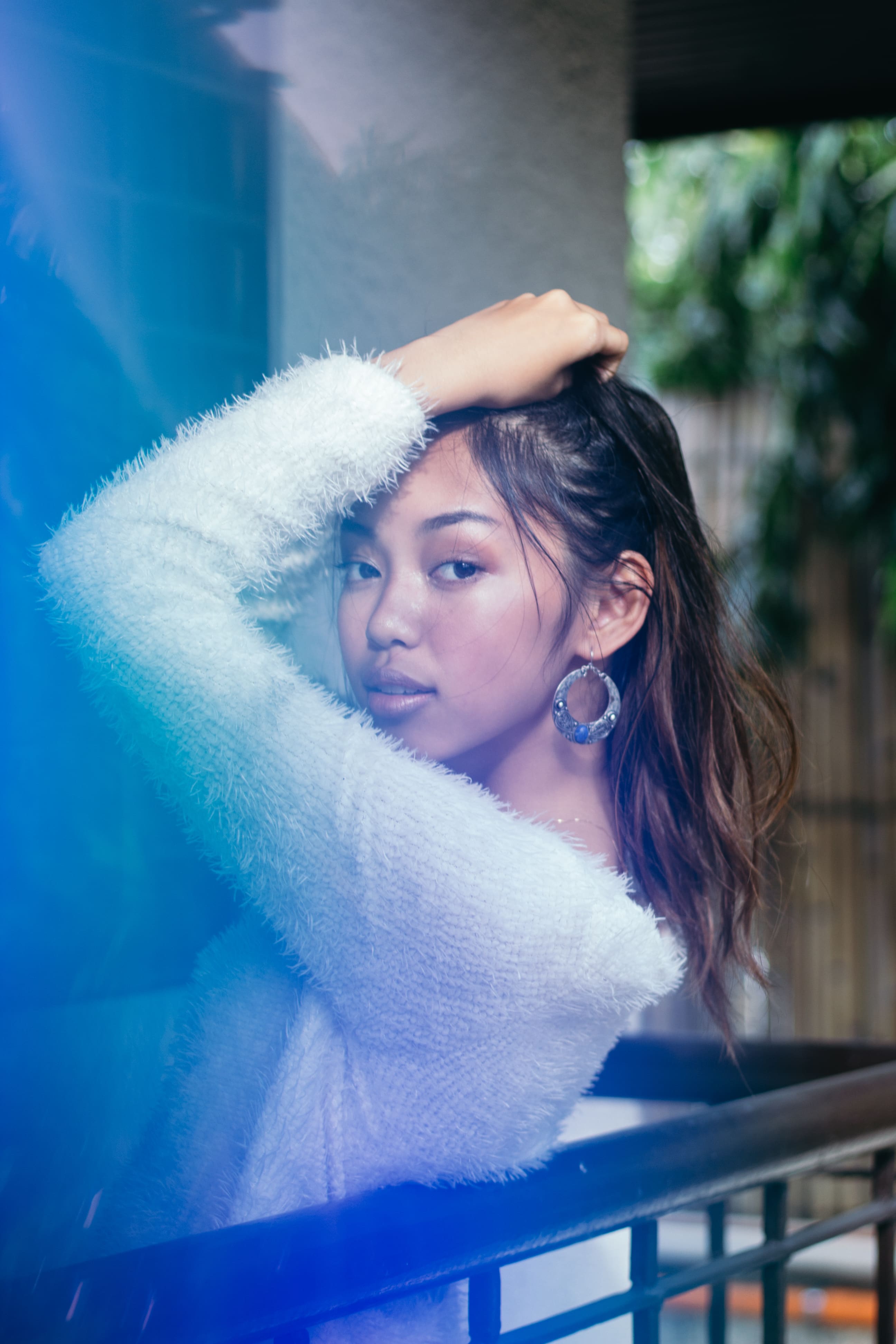 Portrait of a girl in white sweater on the balcony