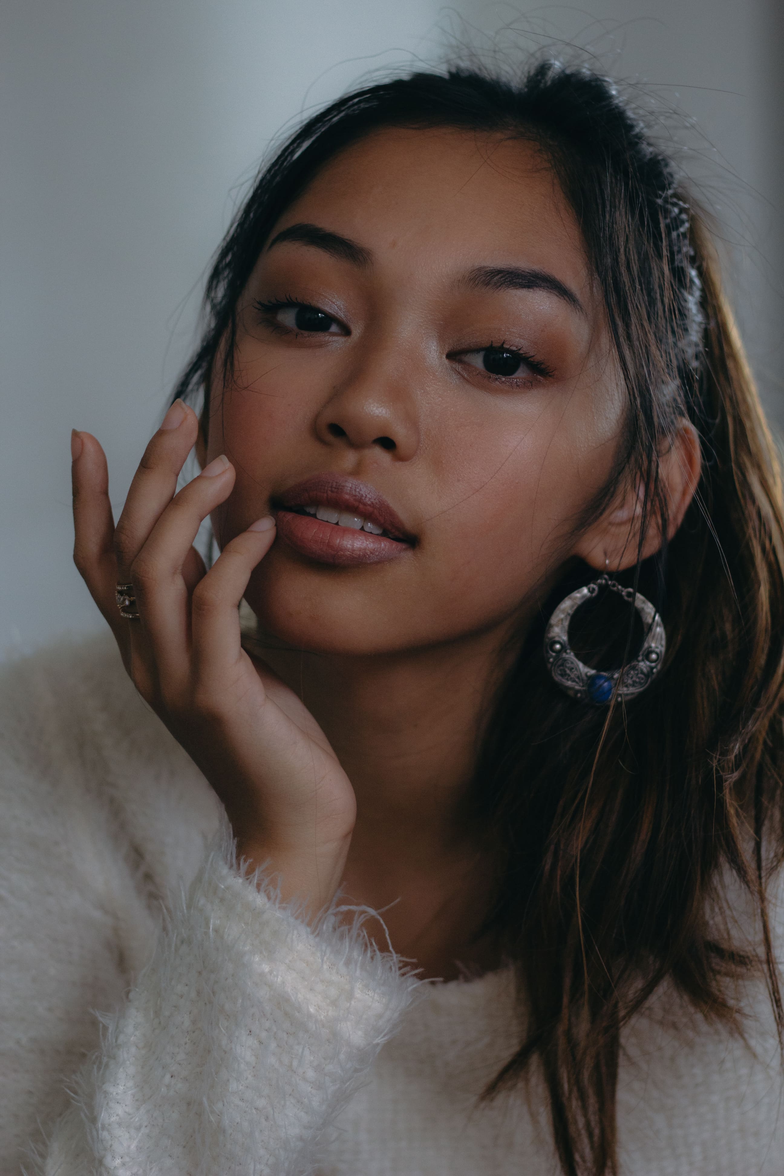 Close up portrait of a girl in white sweater and big earrings
