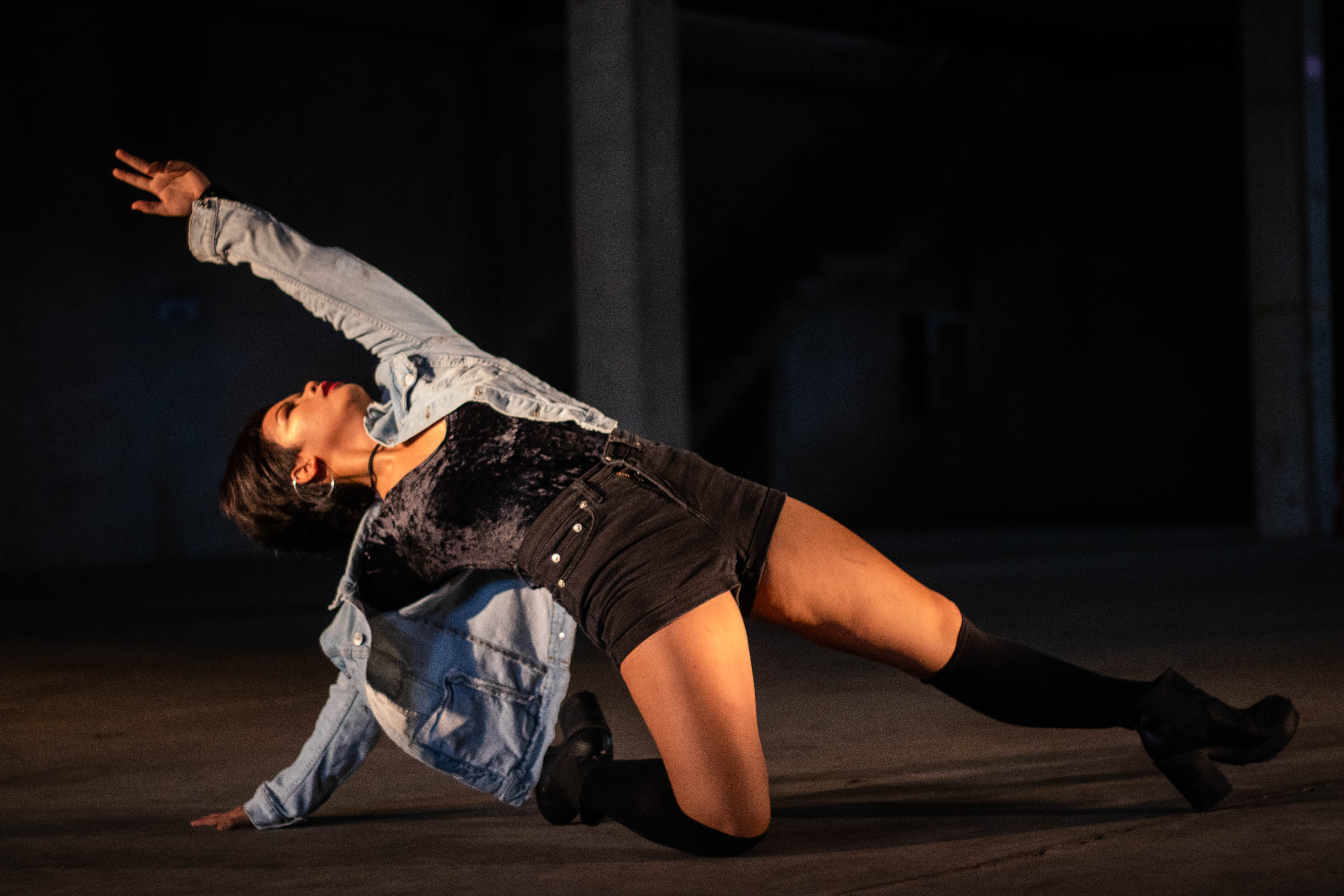 Girl in the middle of a dance move with hands and legs outstretched