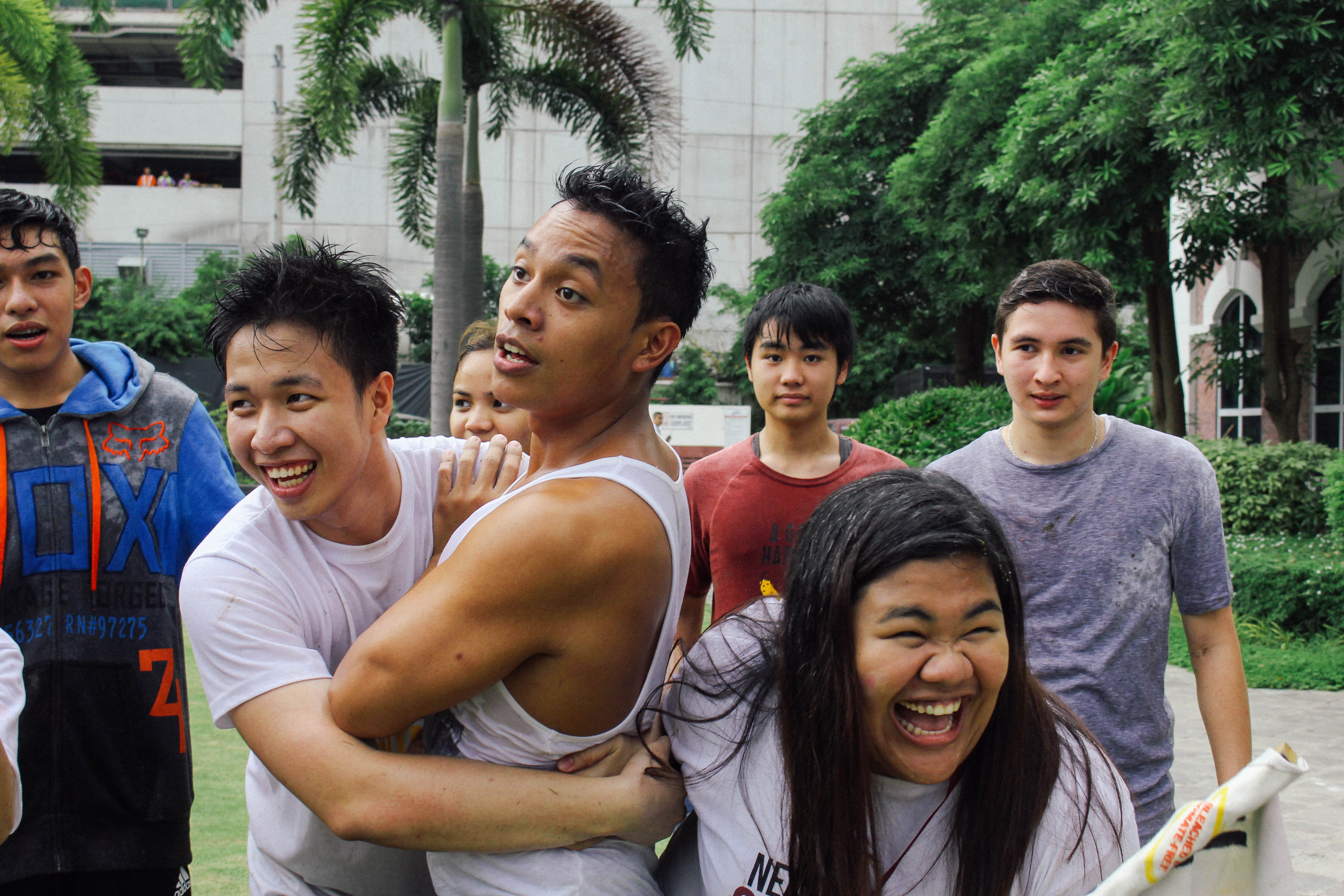 Boy caught between 2 laughing students during a game of chase
