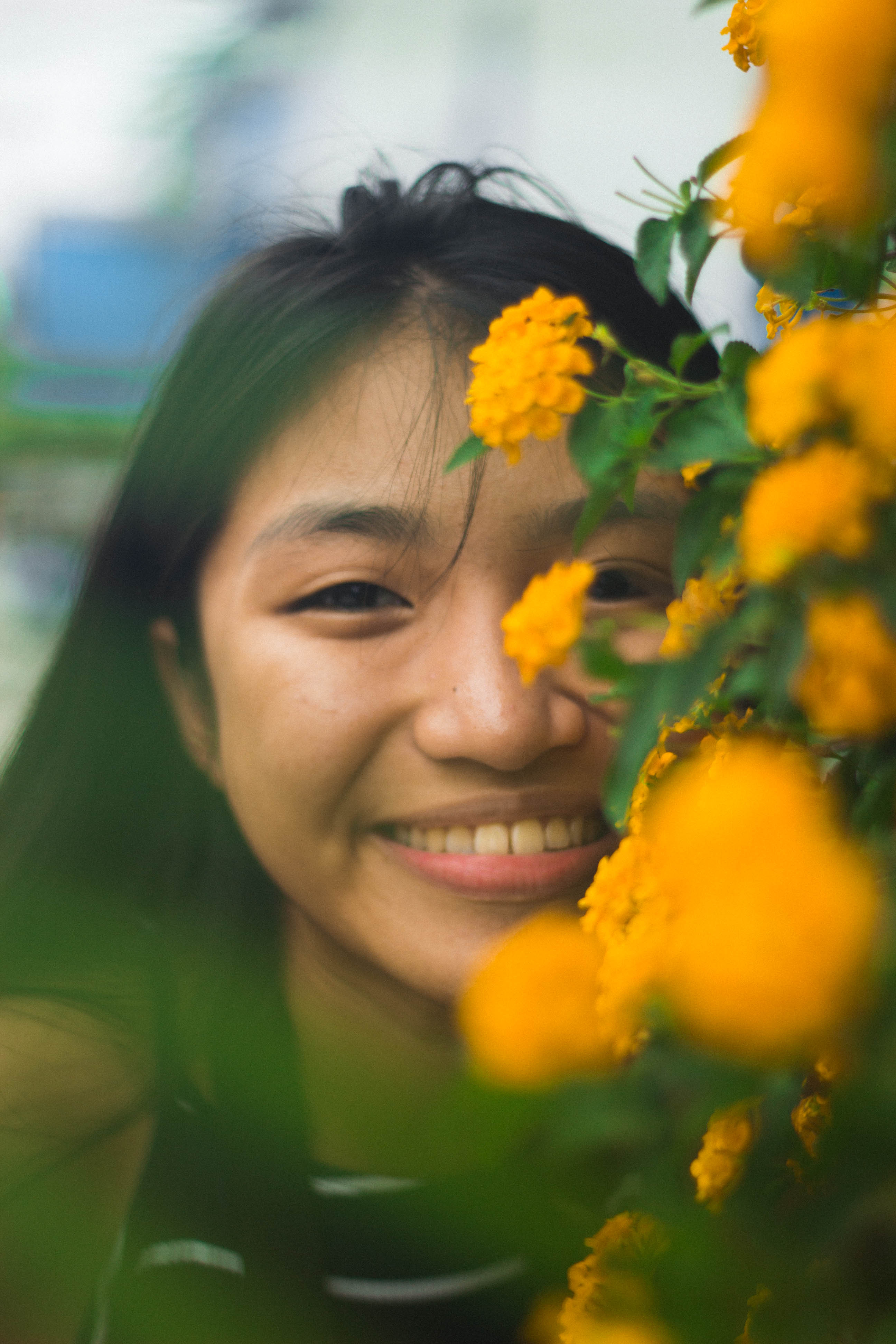 Girl smiling peeking through flowers