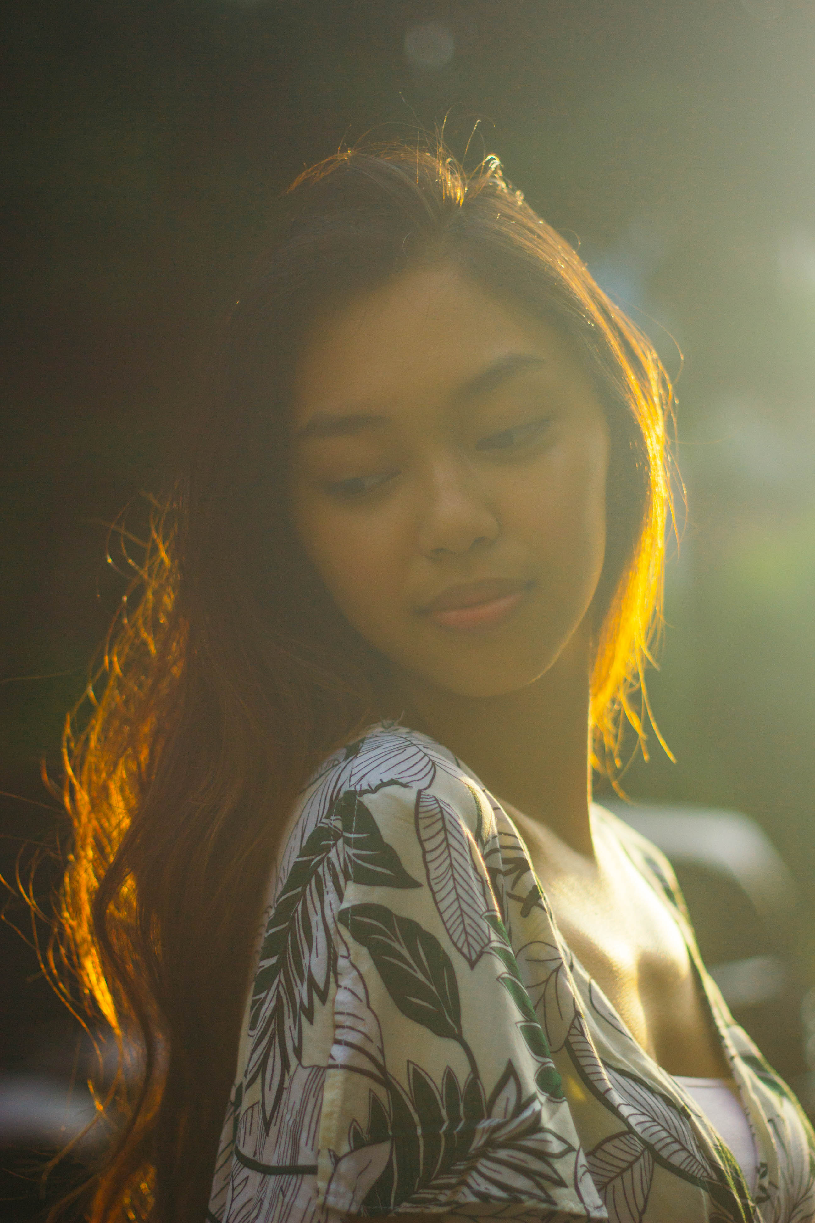 Girl looking sideways to the camera with light of the sun at the back