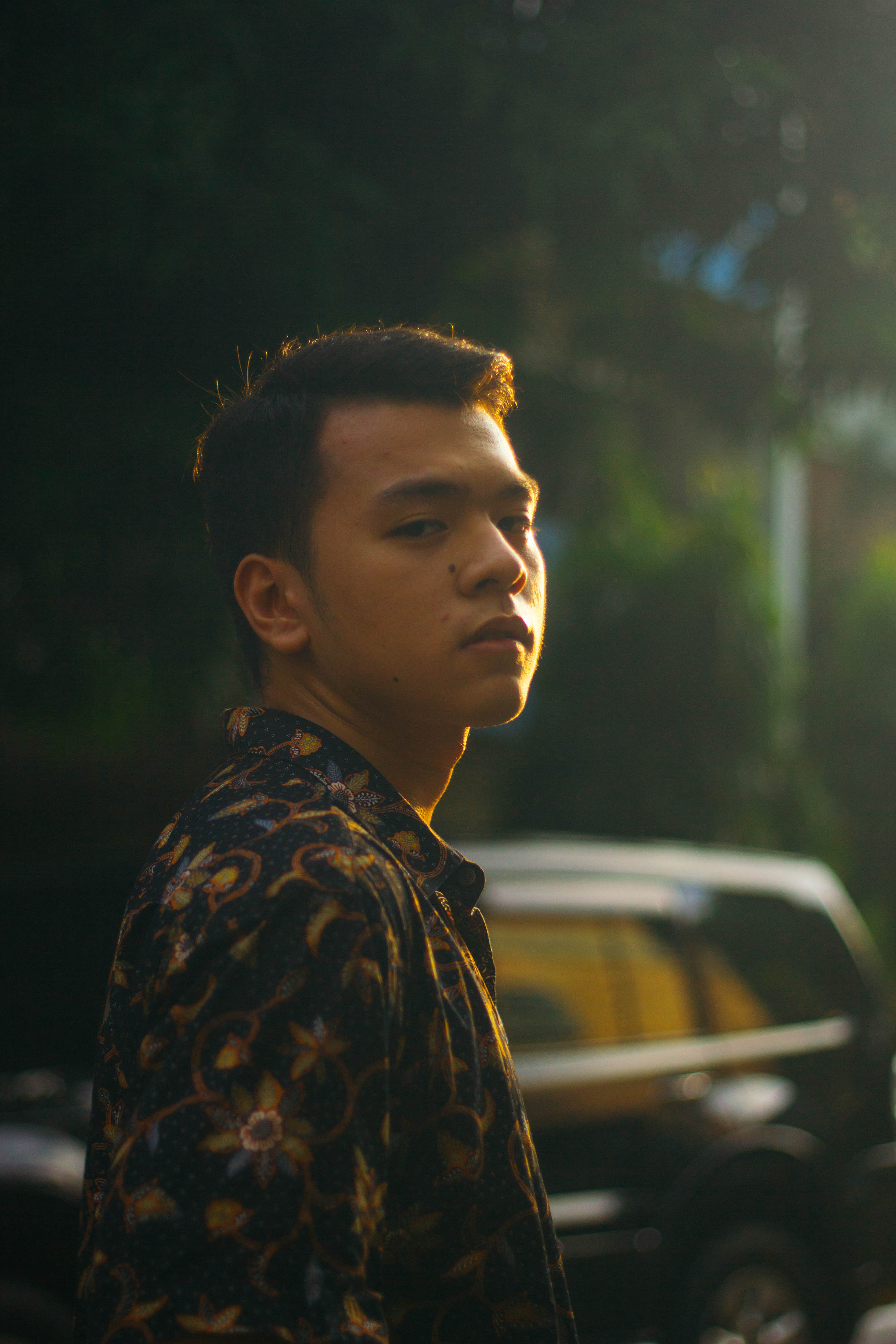 Boy in a floral shirt looking at camera