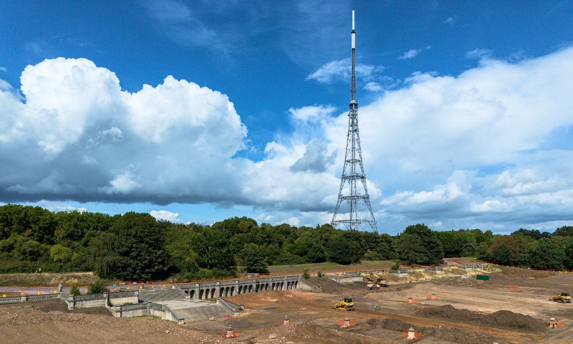 Aerial view of the Italian Terraces at Crystal Palace Park under construction, with diggers on bare soil and the Crystal Palace transmission tower in the background.