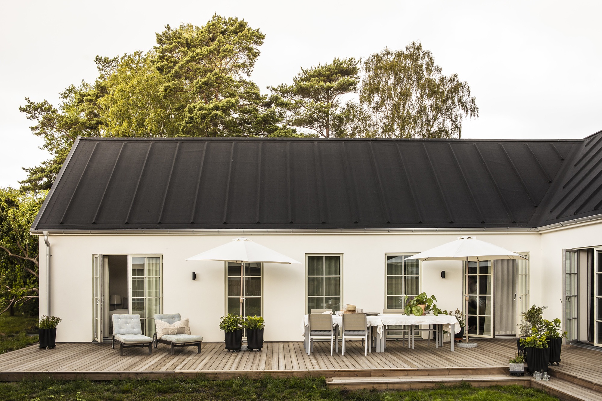 Nybyggt stenhus från dast i äldre klassisk stil med listtäkt svart papptak och vita spröjsade fönster