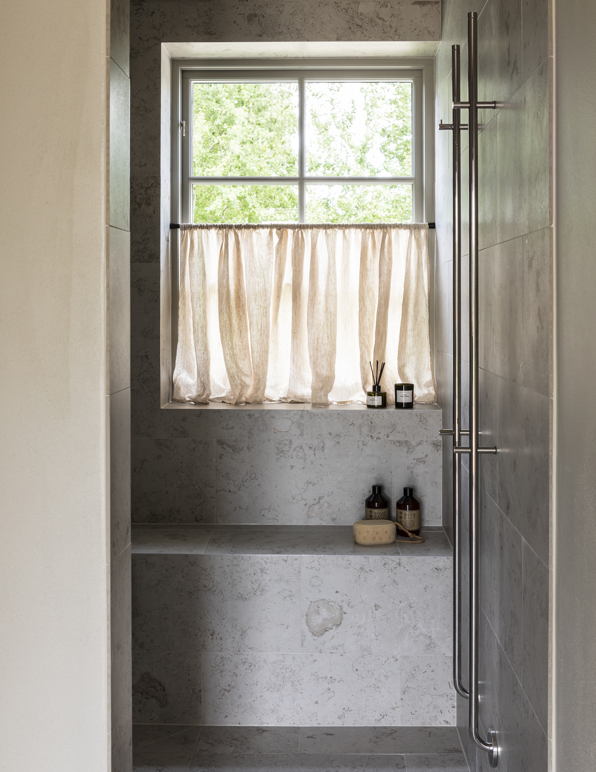 Dast stenhus med vackert kaklad sittbänk i badrummets dusch