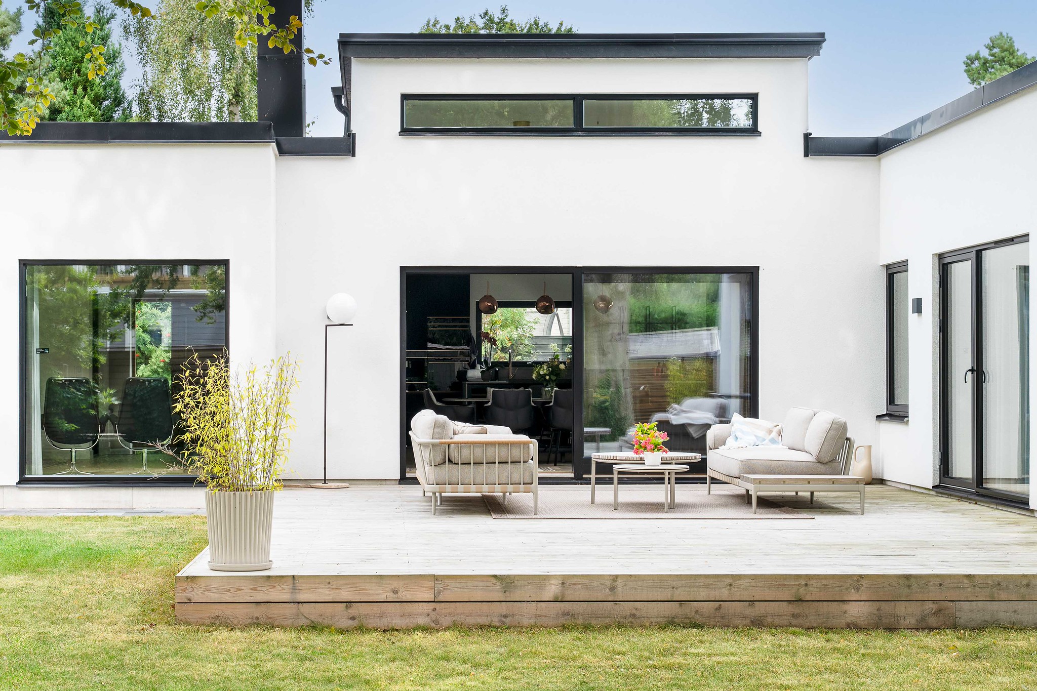 Stenhus i funkisstil med lanternin och en härlig uteplats utanför matplatsen