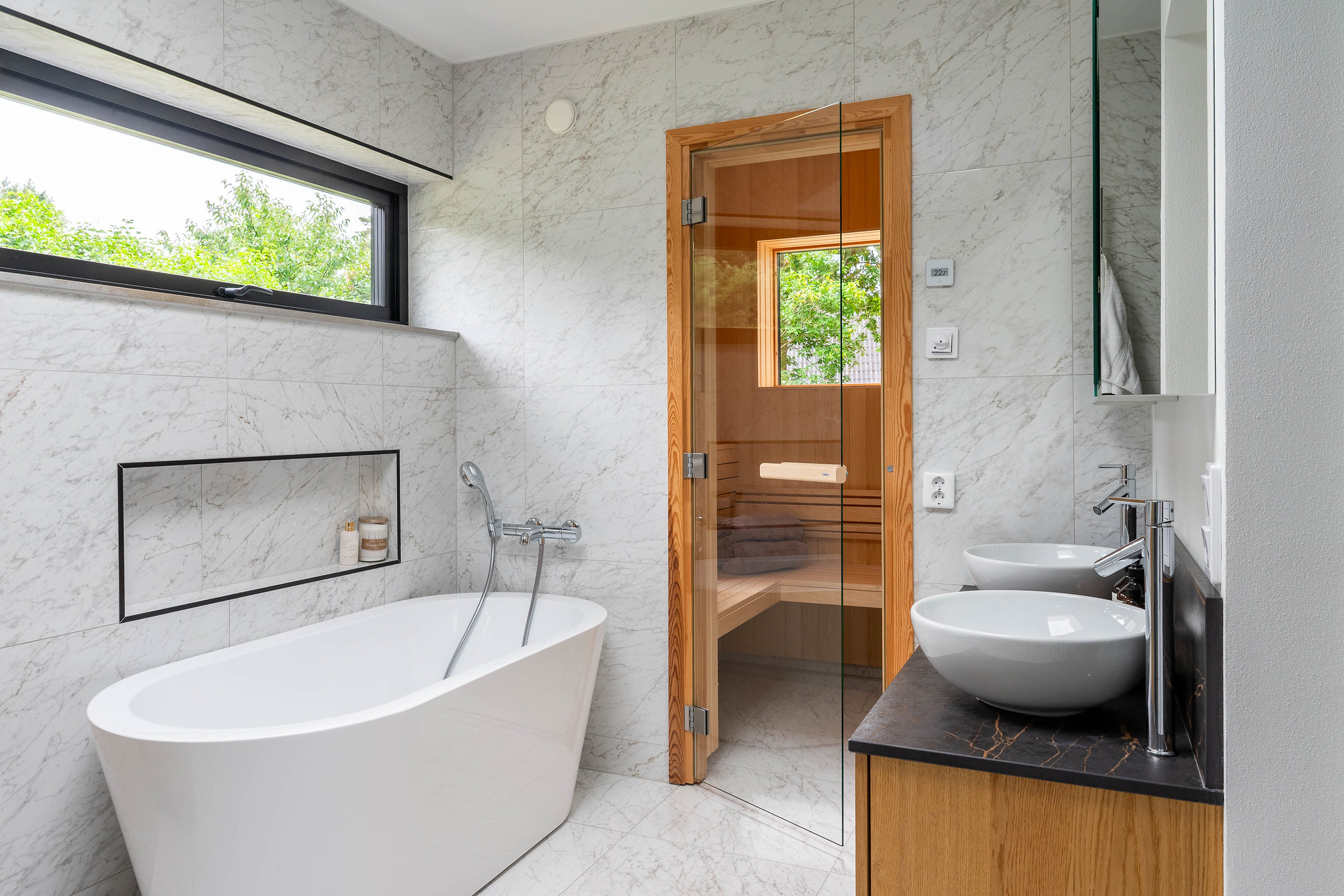 Stilrent badrum med bastu och stor nisch i ett nybyggt dast stenhus