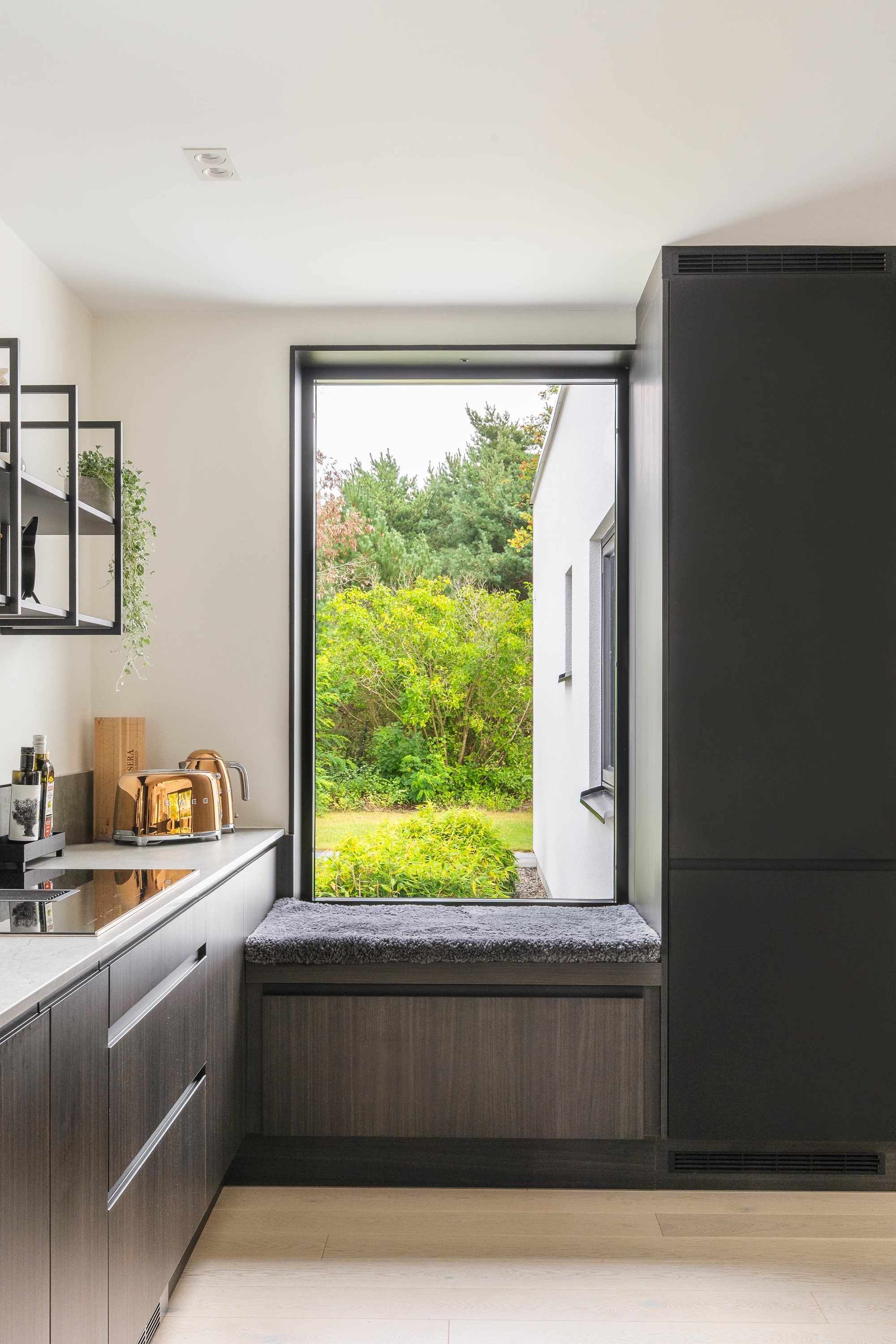 Mysig sittbänk integrerad i köksinredningen i ett dast stenhus 