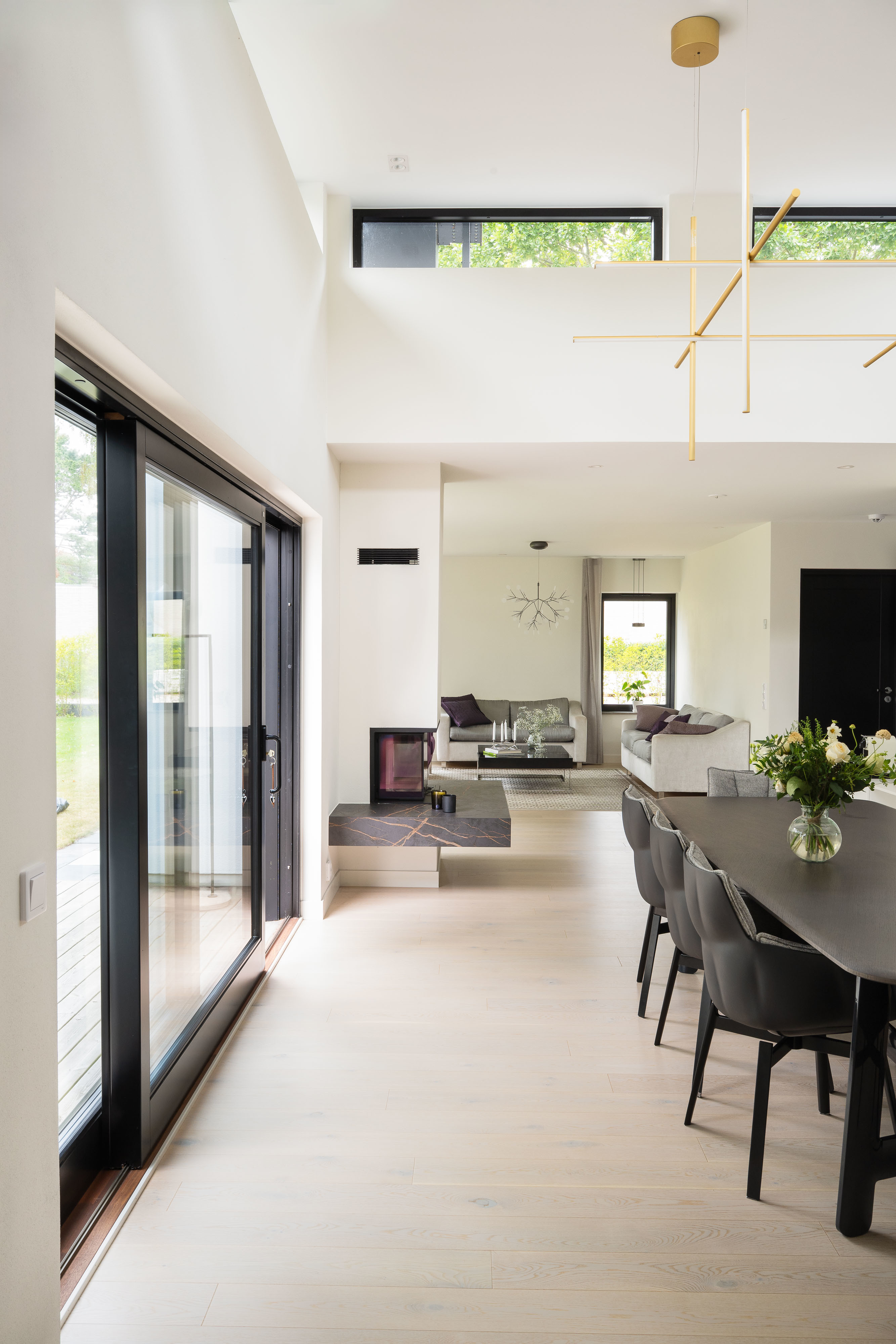 Öppen ljus planlösning med kamin i centrum i ett modernt en-planhus från dast stenhus