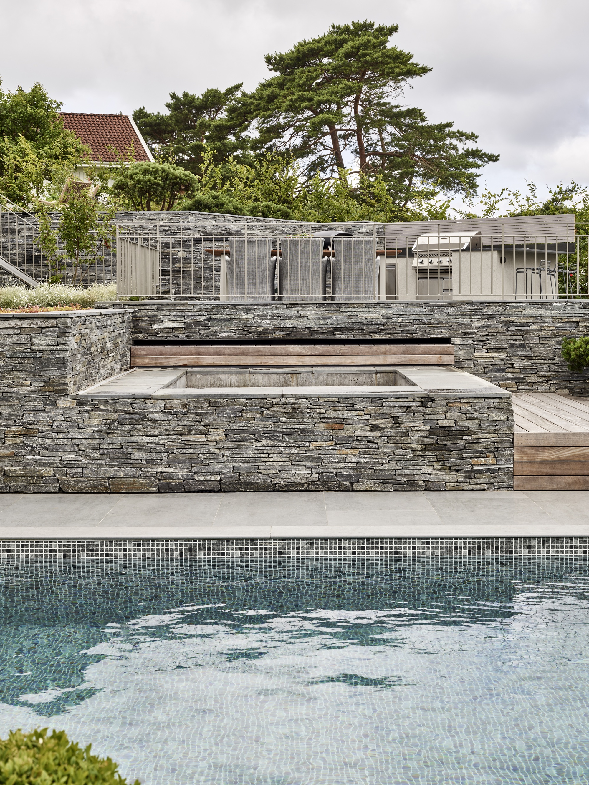 Dast stenhus med stenlagd uteplats med pool 