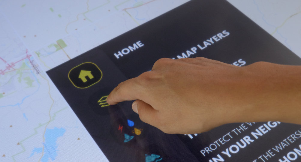 Guests can tap the screen to view maps or explore environmental challenges.