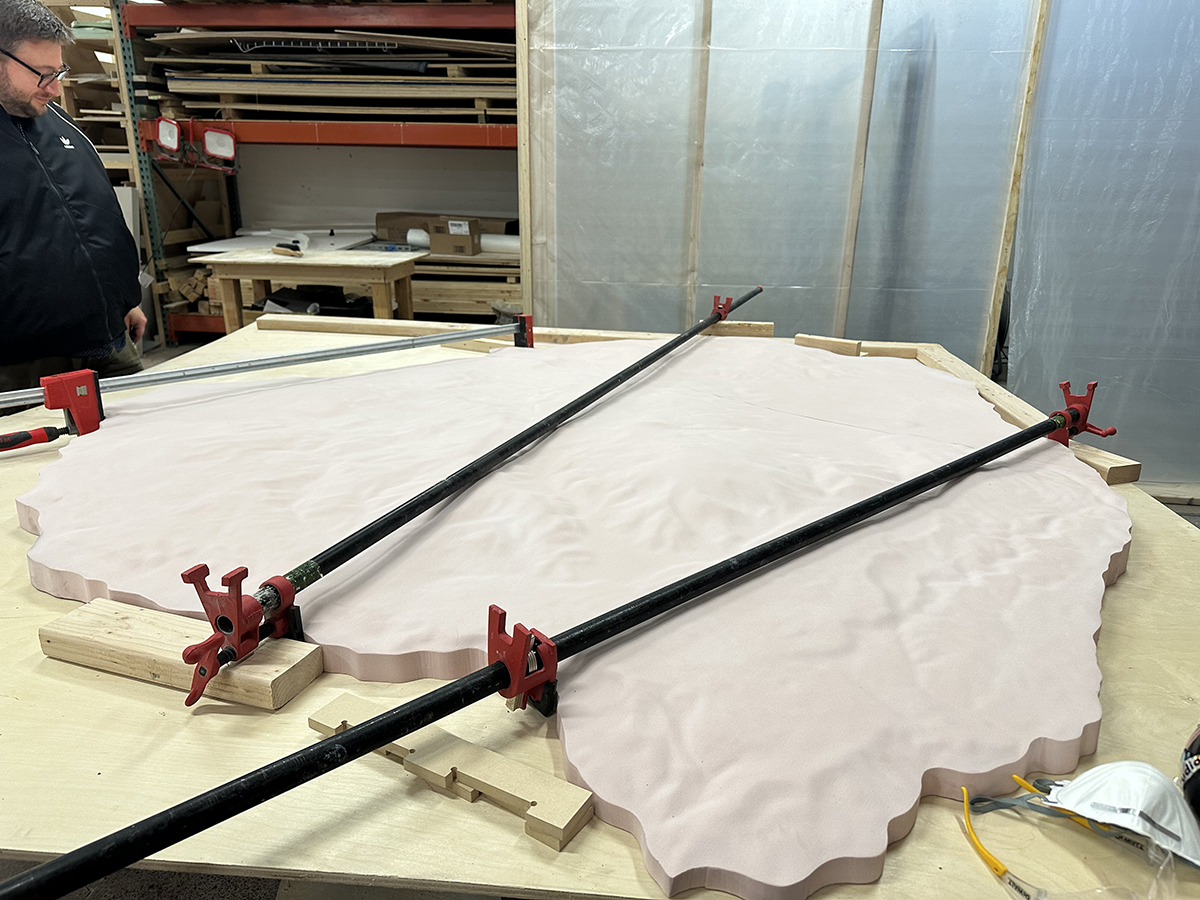 Two sections of the CNC-cut topographic relief being seamed together. The entire exhibit, including the base and screen mounts, was designed and built by our in-house fabrication team.