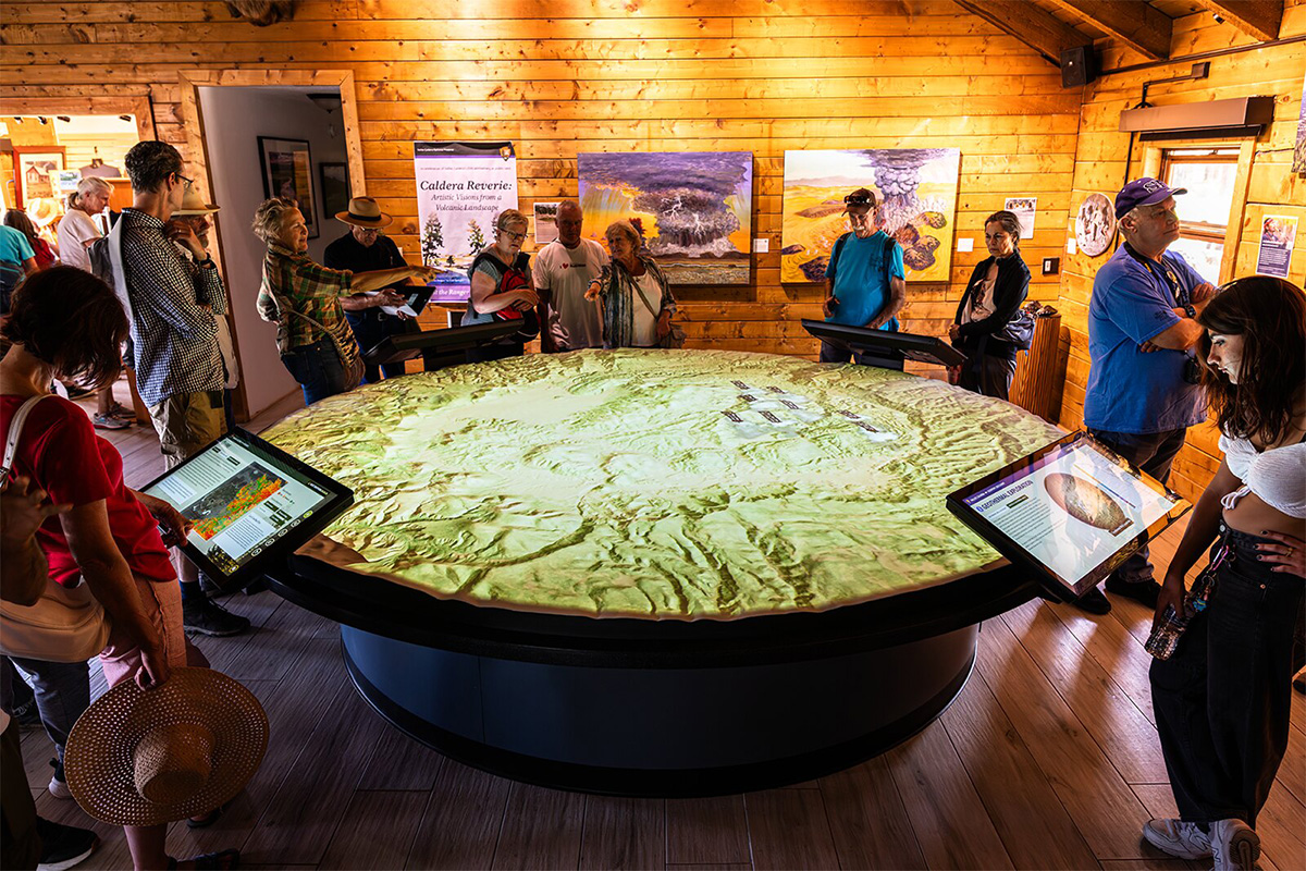 Projection-mapped onto a 12‑foot topographic relief map, the Valles Caldera interactive table brings geology, ecology, and human history alive in immersive color and sound