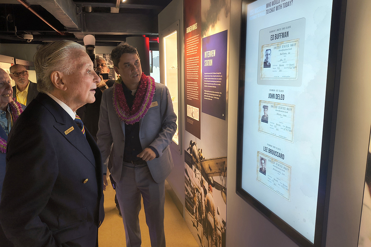 Veteran of the USS Missouri, Ed Buffman, and Curator Frank Clay explore the interactive interview station during the grand opening of the Pathway to Peace exhibit.