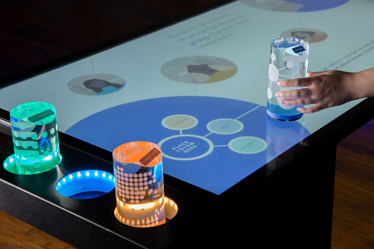 An early example of custom tangibles, with large acrylic totems placed on top of colored pucks, and kept in a custom built LED side table attached to the Platform multitouch table. 