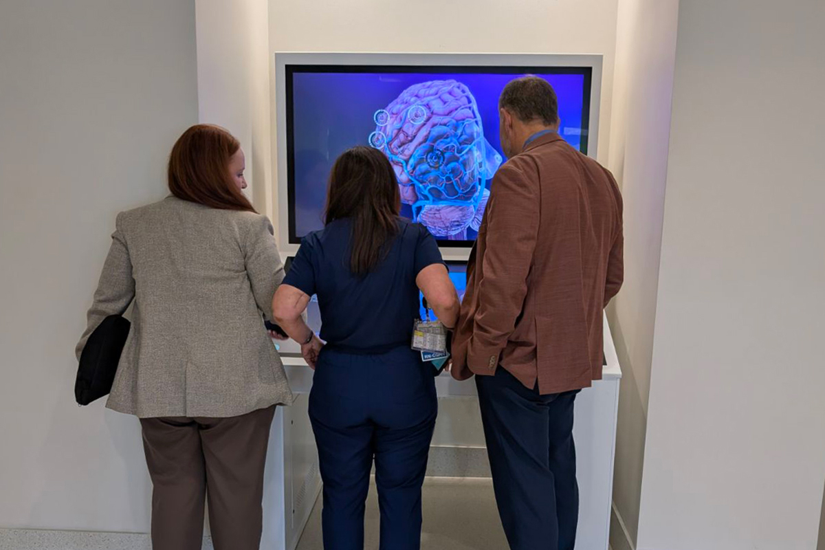 The team at Baptist Health tries out their new custom touch kiosk shortly after installation.