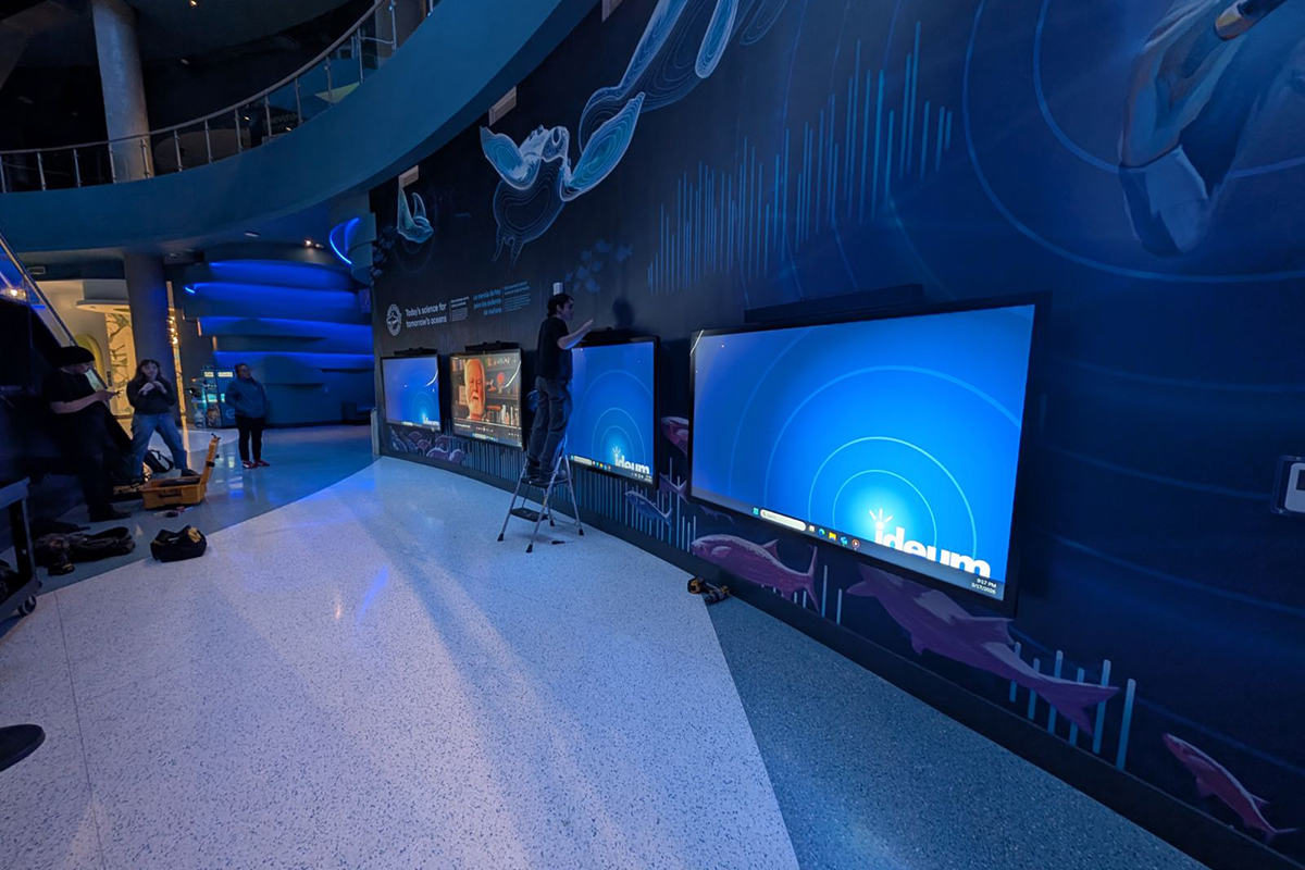 Ideum installation techs check the final alignment on one of the four installed 86” 4k Presenter Touch Displays.
