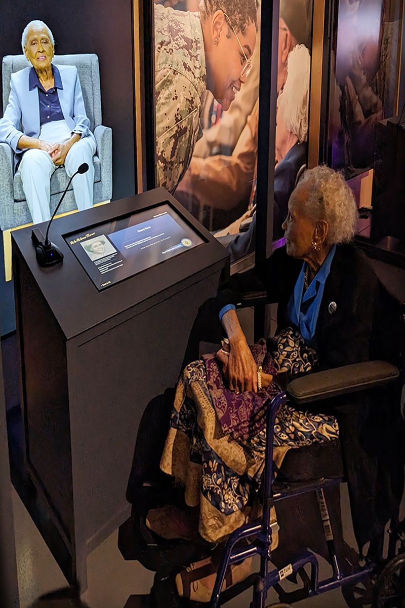 104-year-old Romay Davis interacts with herself at the We Were There interactive biographies.