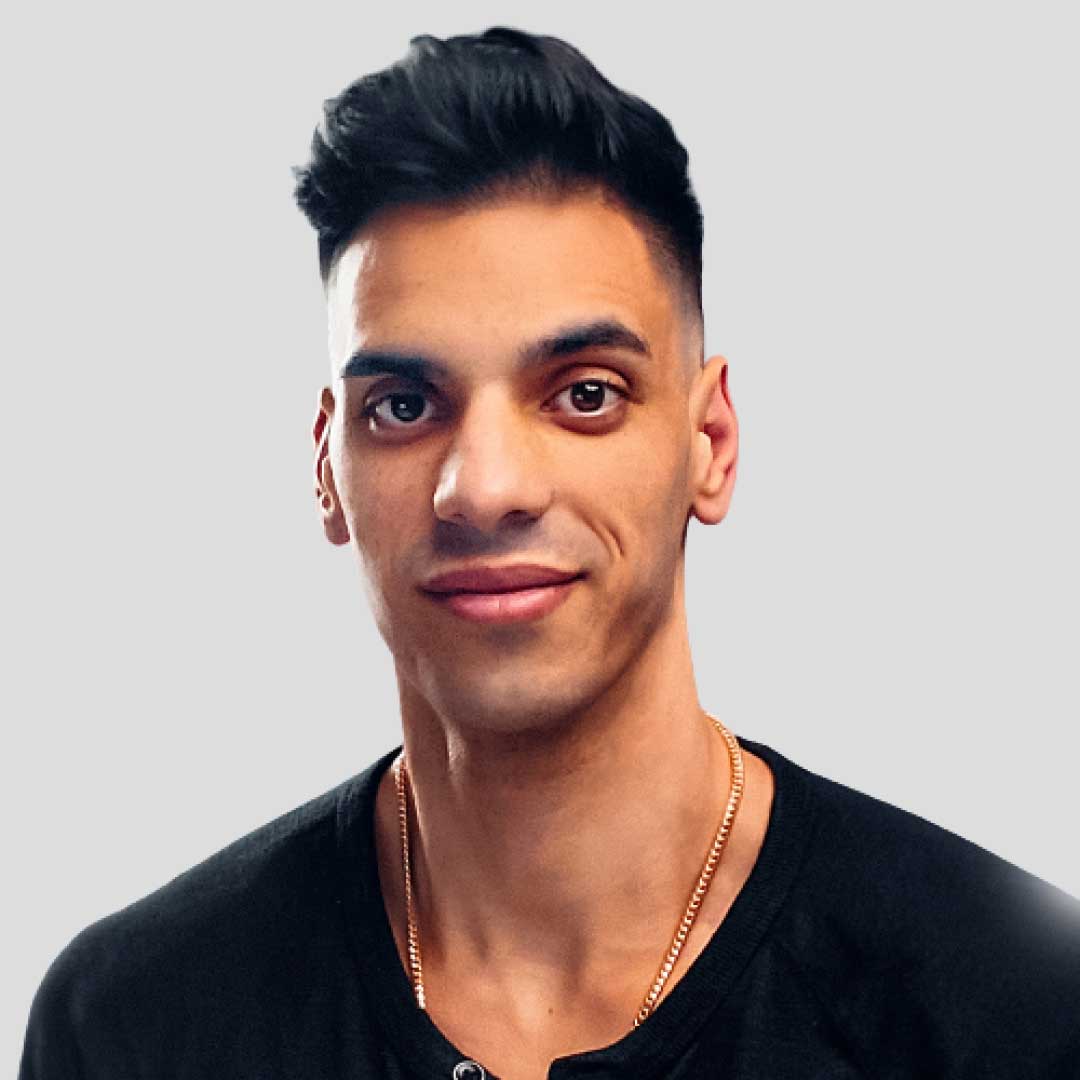 Portrait of a young man with short black hair wearing a black shirt against a plain background.