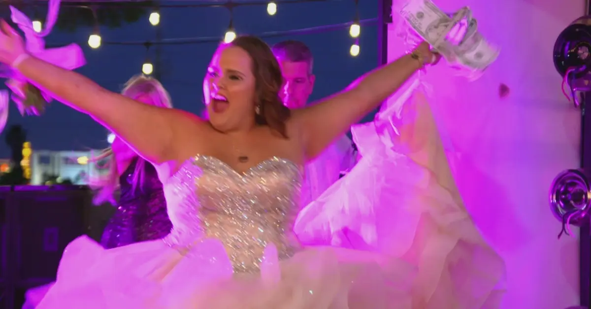 TV still from My Super Sweet 16. A teen girl in a sparkly white gown cheers while holding wads of money.