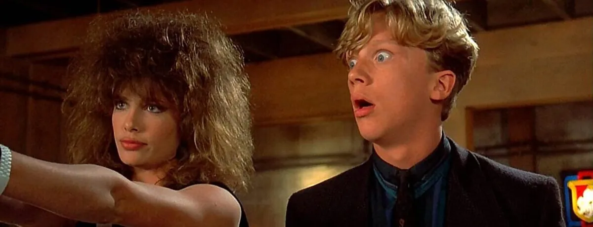 Movie still from Weird Science. A nerdy guy looks shocked at a stunning female supermodel.