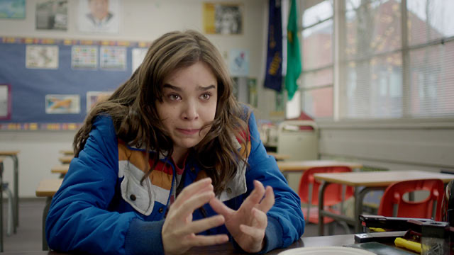 Movie still from Edge of Seventeen. A teen girl sits in an empty classroom looking upset.