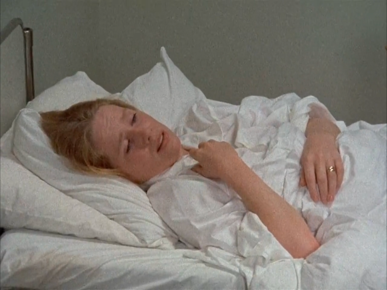 TV still from Scenes From A Marriage. A woman lies in bed, looking forlorn.