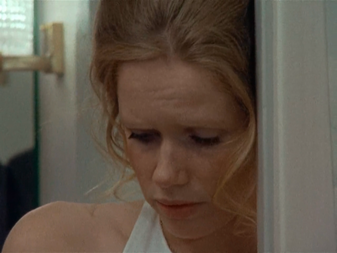 TV still from Scenes From A Marriage. A woman stands in a doorway looking upset.