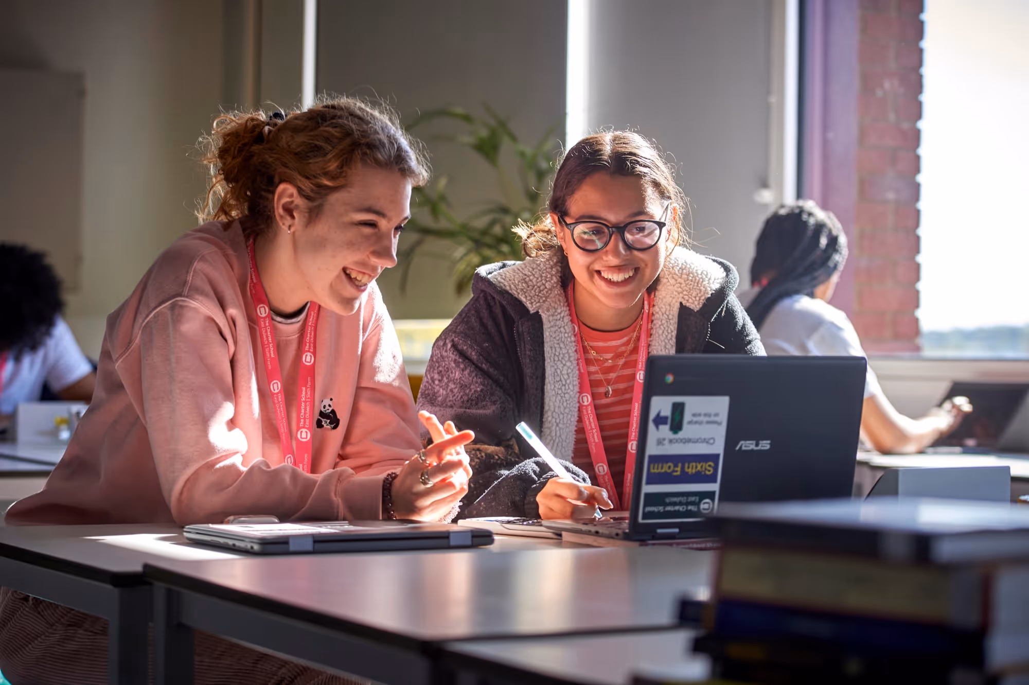 Two students sit at a laptop discussing their work during a lesson at The Charter School East Dulwich