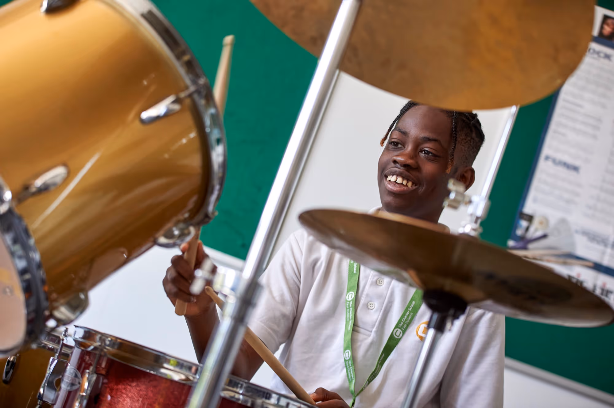 A student playing drums during a music lesson at The Charter School East Dulwich
